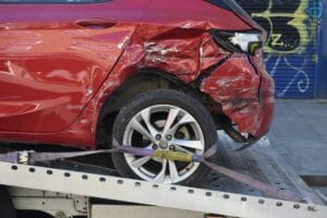 crashed red car in a flat bed - what can a lawyer do for you after a car accident